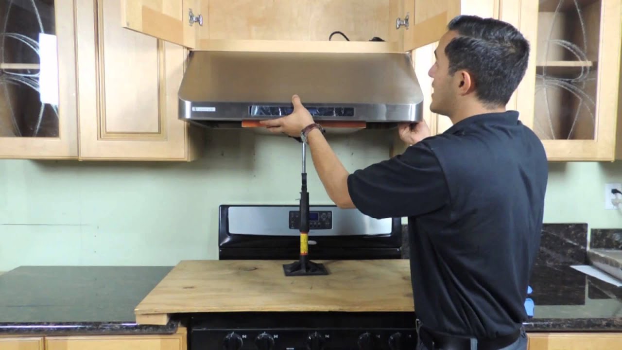 Kitchen hood installer working on commercial extraction system in Cheltenham